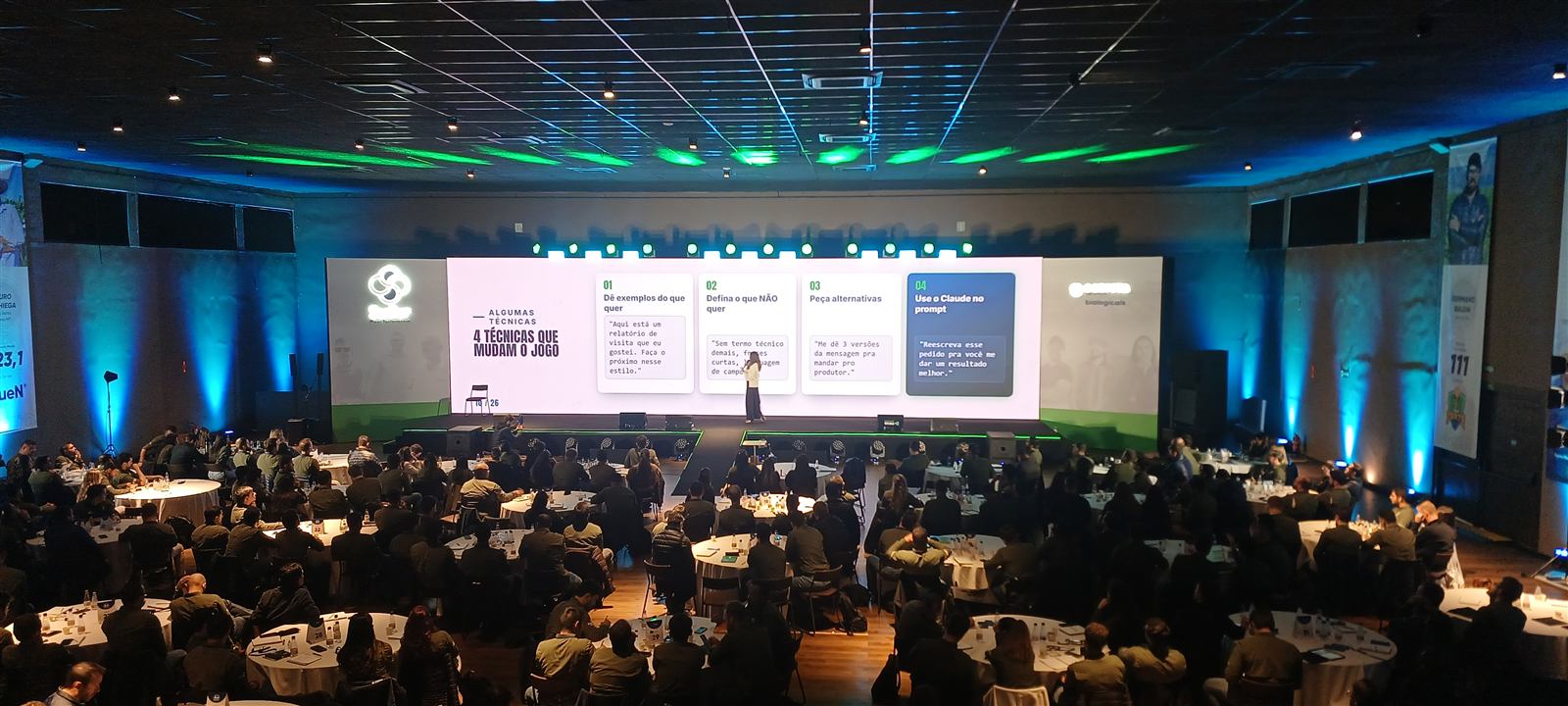 Auditório lotado na convenção Stoller com o slide 4 técnicas que mudam o jogo e exemplos de prompt reais